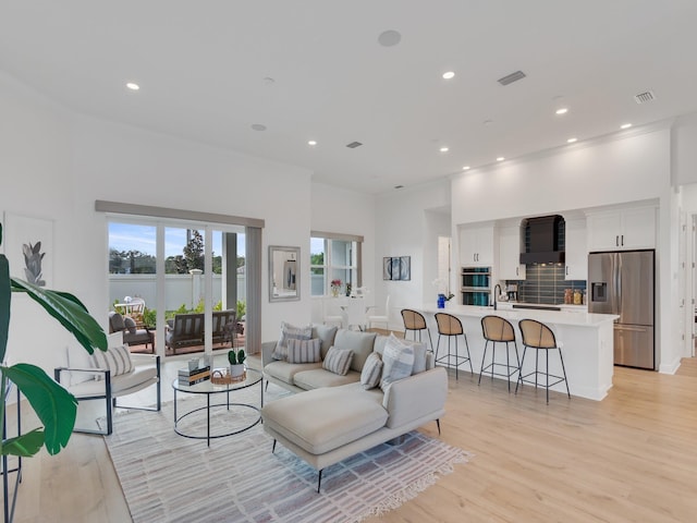 living room with sink and light hardwood / wood-style floors