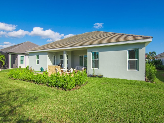 back of property with outdoor lounge area and a yard