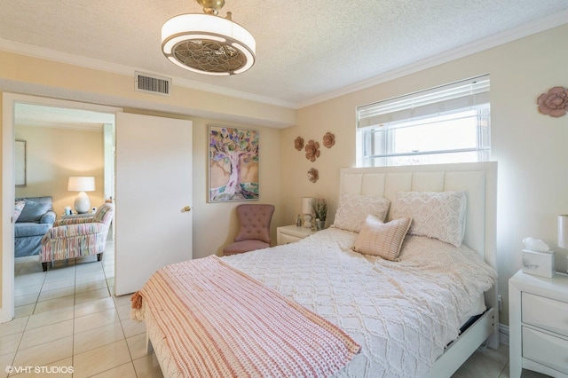 bedroom featuring ornamental molding, light tile patterned floors, and a textured ceiling