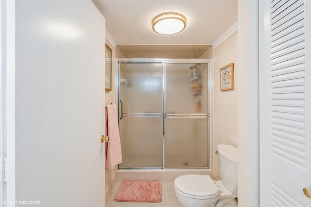 bathroom featuring tile patterned flooring, crown molding, a shower with shower door, and toilet