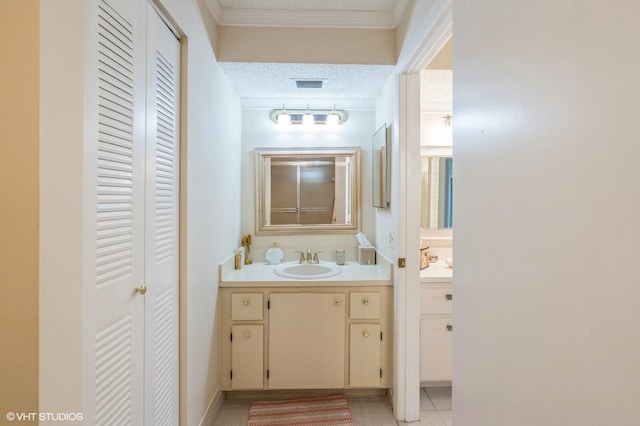 bathroom with vanity, ornamental molding, and a textured ceiling