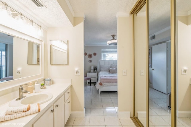 bathroom with vanity, crown molding, tile patterned floors, and a textured ceiling