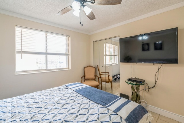 tiled bedroom with ceiling fan, crown molding, a closet, and a textured ceiling