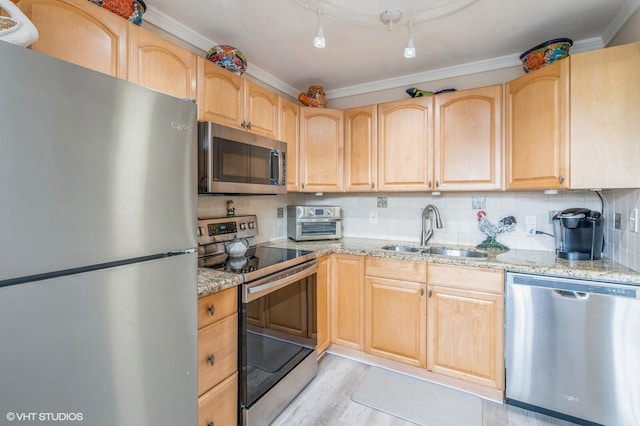 kitchen with appliances with stainless steel finishes, sink, backsplash, light stone counters, and light brown cabinets