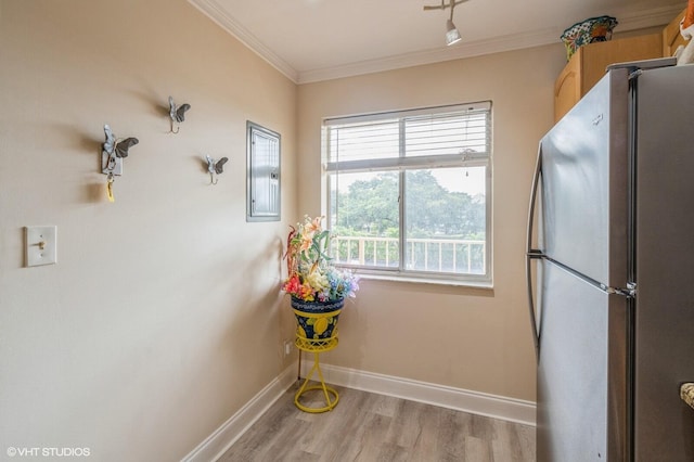 clothes washing area featuring crown molding, electric panel, and light hardwood / wood-style flooring