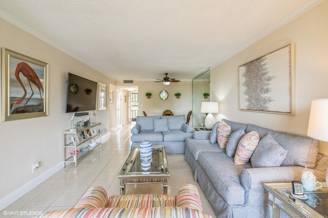 tiled living room with ceiling fan, ornamental molding, and a textured ceiling