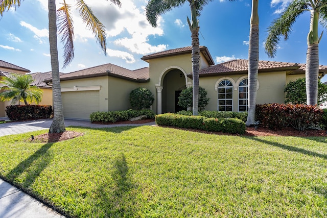 mediterranean / spanish-style house featuring a garage and a front lawn