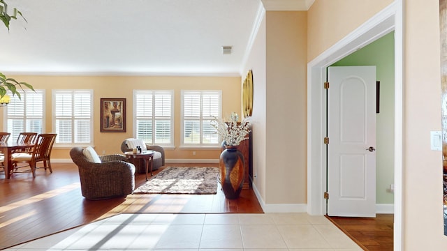 tiled living room with plenty of natural light and crown molding