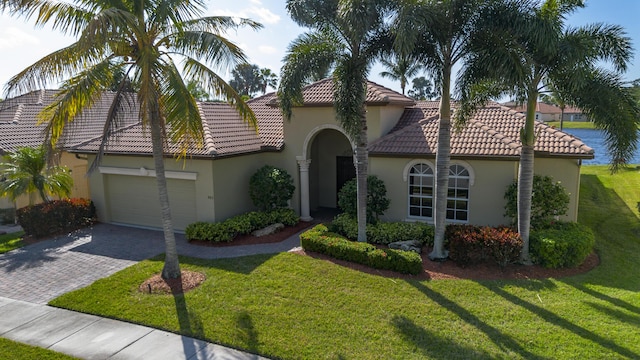 mediterranean / spanish house with a garage and a front yard