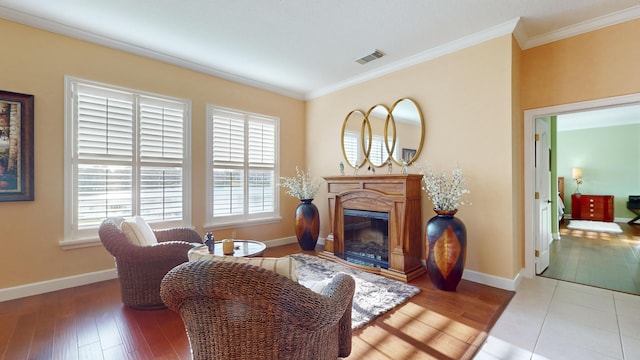 living area with hardwood / wood-style floors and ornamental molding