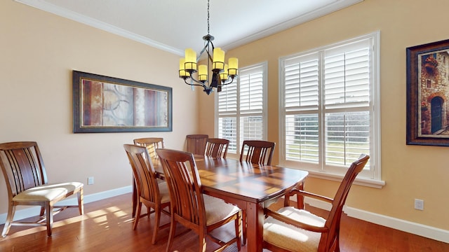 dining space featuring hardwood / wood-style floors, ornamental molding, and a chandelier