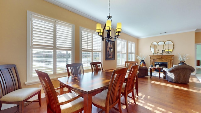 dining room with crown molding, wood-type flooring, and a notable chandelier