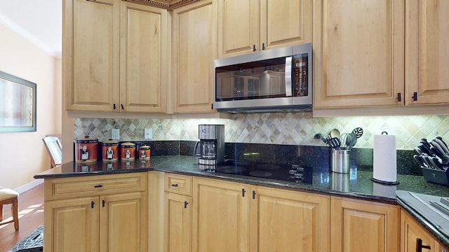 kitchen featuring ornamental molding, backsplash, and black cooktop