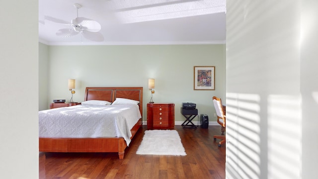 bedroom with dark hardwood / wood-style floors, ceiling fan, and crown molding