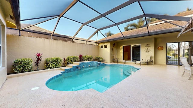 view of pool featuring glass enclosure and a patio area