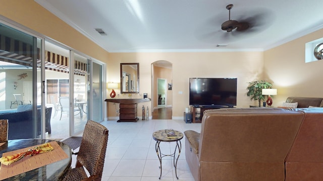 tiled living room with ceiling fan and crown molding