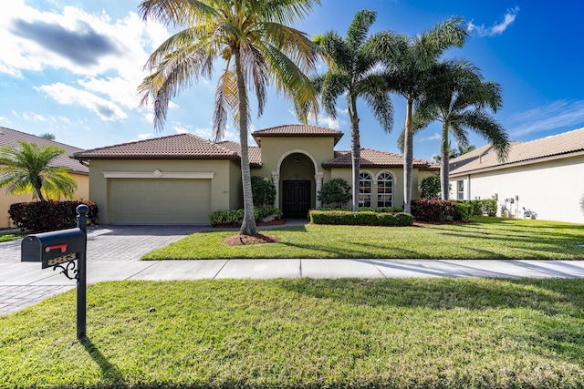 mediterranean / spanish-style house with a garage and a front lawn