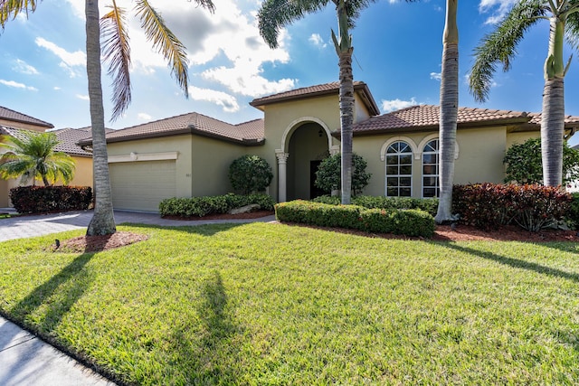 mediterranean / spanish-style home featuring a front yard and a garage