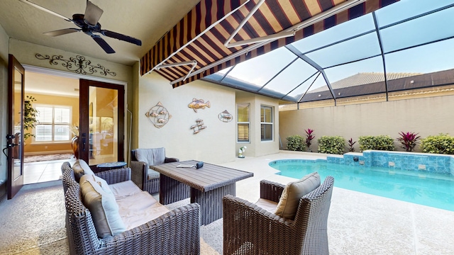 view of swimming pool with a patio, glass enclosure, and ceiling fan