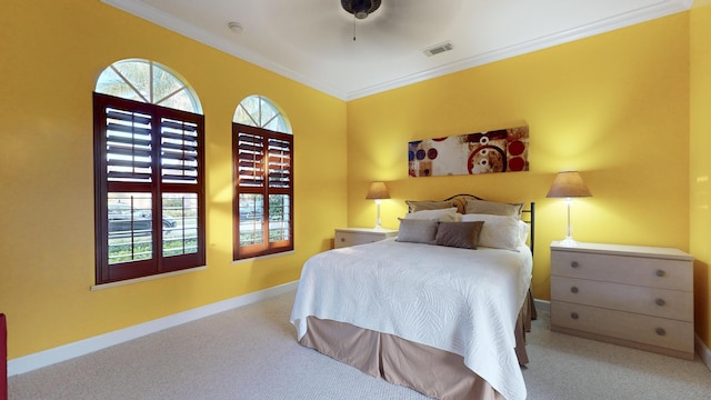 carpeted bedroom with ceiling fan and ornamental molding