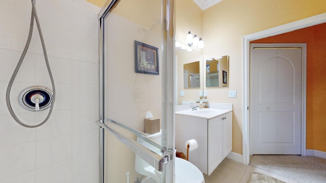 bathroom featuring tile patterned flooring, vanity, a shower with shower door, and ornamental molding