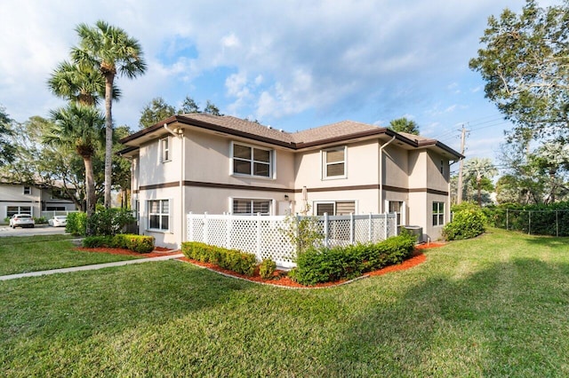 back of property featuring a lawn and central AC