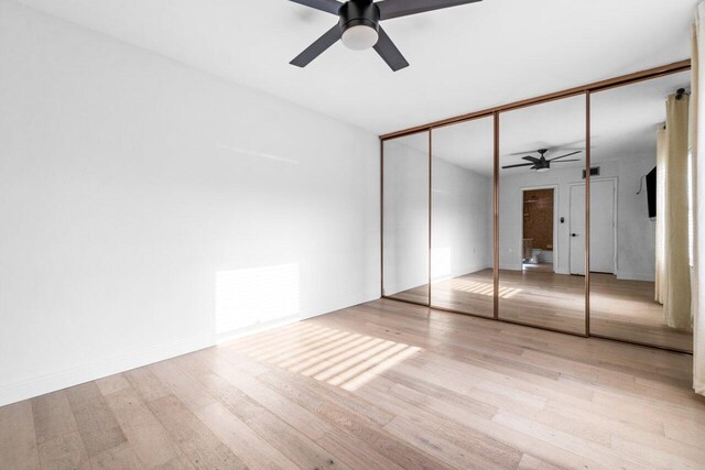 unfurnished bedroom with ceiling fan, light hardwood / wood-style floors, and connected bathroom