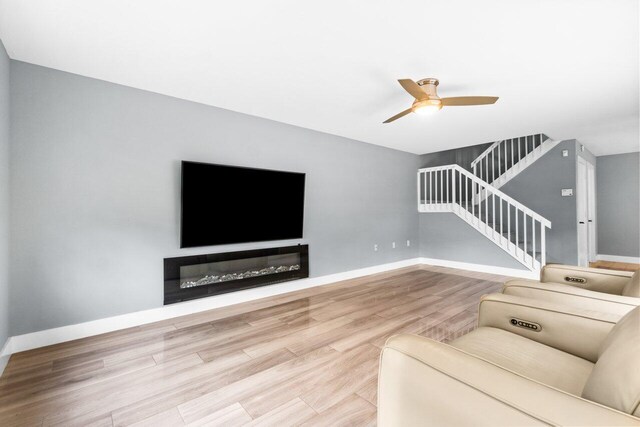 living room featuring light hardwood / wood-style floors and ceiling fan