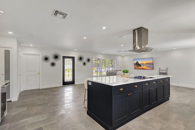 kitchen featuring a kitchen bar, light stone countertops, black electric cooktop, a kitchen island, and range hood