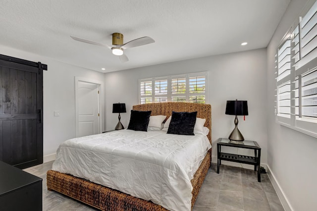 bedroom featuring a barn door and ceiling fan