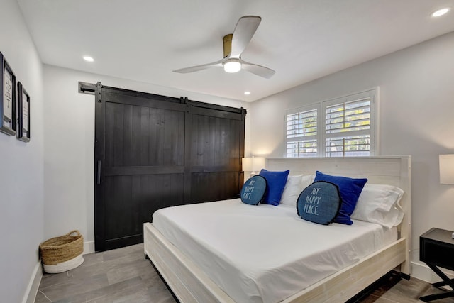 bedroom with a barn door and ceiling fan