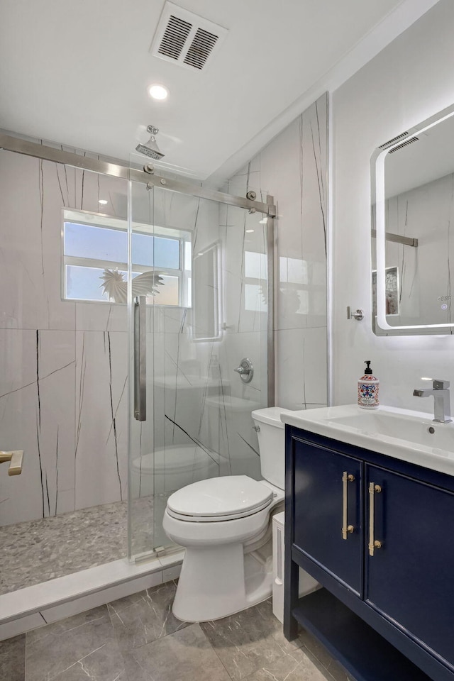 bathroom featuring vanity, toilet, and a shower with shower door