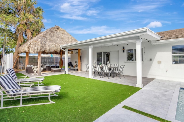 back of house with a patio area, an outdoor living space, and a yard