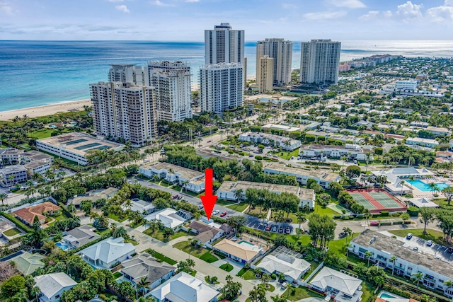 birds eye view of property with a water view and a beach view