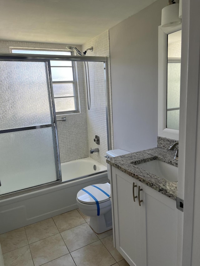 full bathroom featuring shower / bath combination with glass door, vanity, toilet, and tile patterned flooring