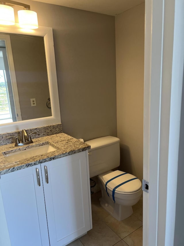 bathroom featuring tile patterned floors, vanity, and toilet