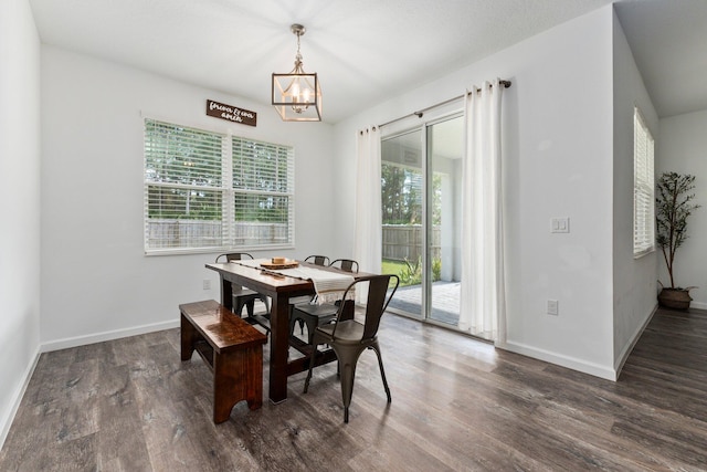 dining space featuring dark hardwood / wood-style flooring and a chandelier