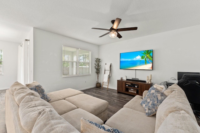 living room with ceiling fan, dark hardwood / wood-style floors, and a textured ceiling