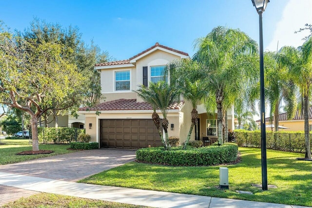 mediterranean / spanish-style house featuring a front yard and a garage