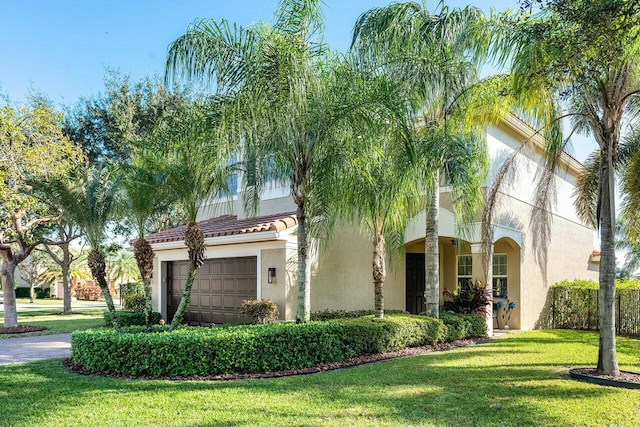 mediterranean / spanish home with a garage and a front lawn