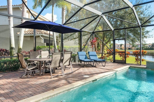 view of pool with a patio, a water view, and a lanai