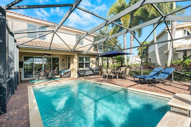 view of swimming pool featuring a lanai, a patio area, and ceiling fan