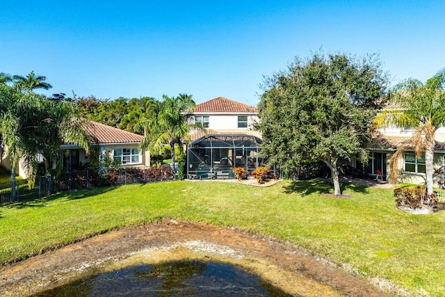 rear view of property with a lanai and a yard