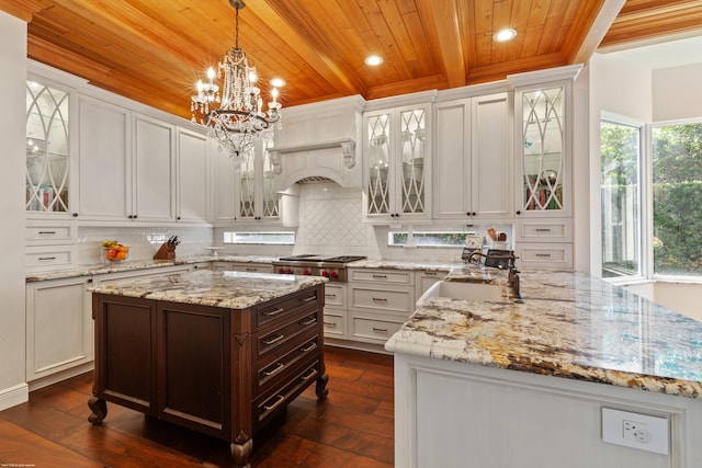 kitchen featuring stainless steel gas cooktop, white cabinets, wood ceiling, and a sink