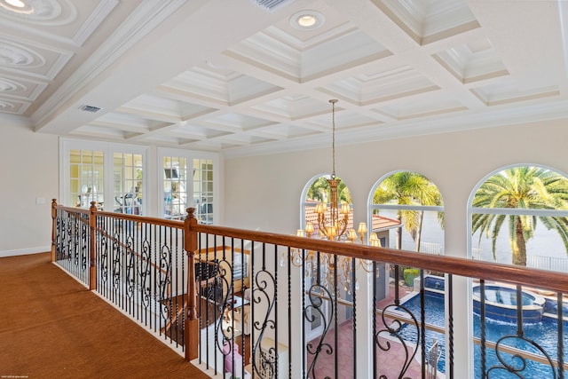 hall with visible vents, crown molding, beam ceiling, an inviting chandelier, and coffered ceiling