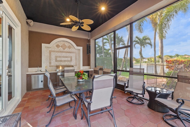 sunroom / solarium with a ceiling fan and a sink