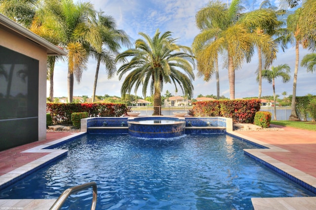 view of swimming pool with a patio area, fence, and a pool with connected hot tub