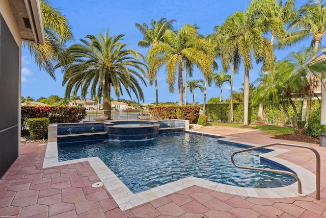 view of swimming pool featuring a patio, a fenced backyard, and a pool with connected hot tub