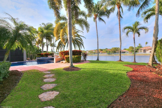 view of yard with a water view and a pool with connected hot tub