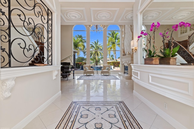 foyer featuring a chandelier, light tile patterned floors, and baseboards